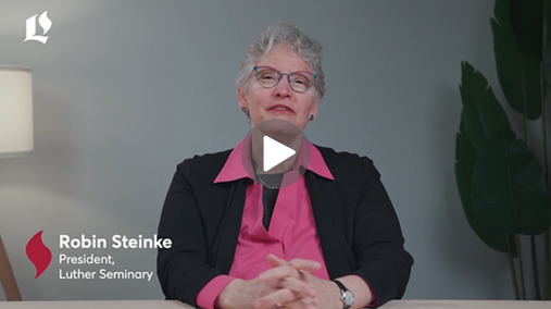 President Steinke wears a pink shirt and black blazer, with her hands resting on the table. Photograph is overlaid with her name, title, Luther Seminary logo, and a video "play" button.