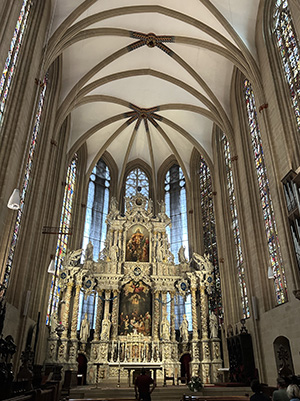 Interior of a cathedral with a vaulted ceiling and ornate altar.