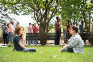 students sitting in the grass and talking