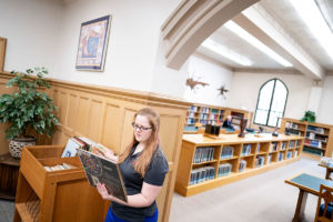 Recent M.Div. graduate Nellie Hennager browses materials in Gullixson Hall's library.