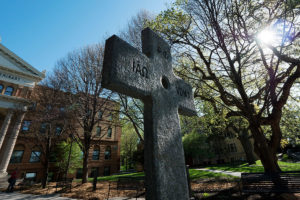 A Celtic cross stands in front of Bockman Hall on Luther Seminary’s campus