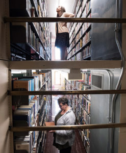 M.Div. students Anna Wolf (top) and Miranda Joebgen peruse books in Gullixson Hall's library