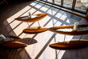 Wooden boat sculptures illuminated by sunlight in Olson Campus Center