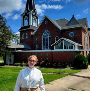 Luther Seminary alum and graduate preaching fellow Katie Weiland stands in front of Lands Lutheran Church in Zumbrota, Minnesota
