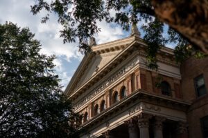The upper facade of Bockman Hall viewed through oak branches.
