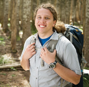 student backpacking in woods