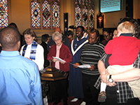 Hollie Holt-Woehl ’93 M.Div., ’08 Ph.D. (far left), leads a baptism service at Christ the River of Life Lutheran Church. 