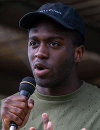 Black person speaking into a microphone